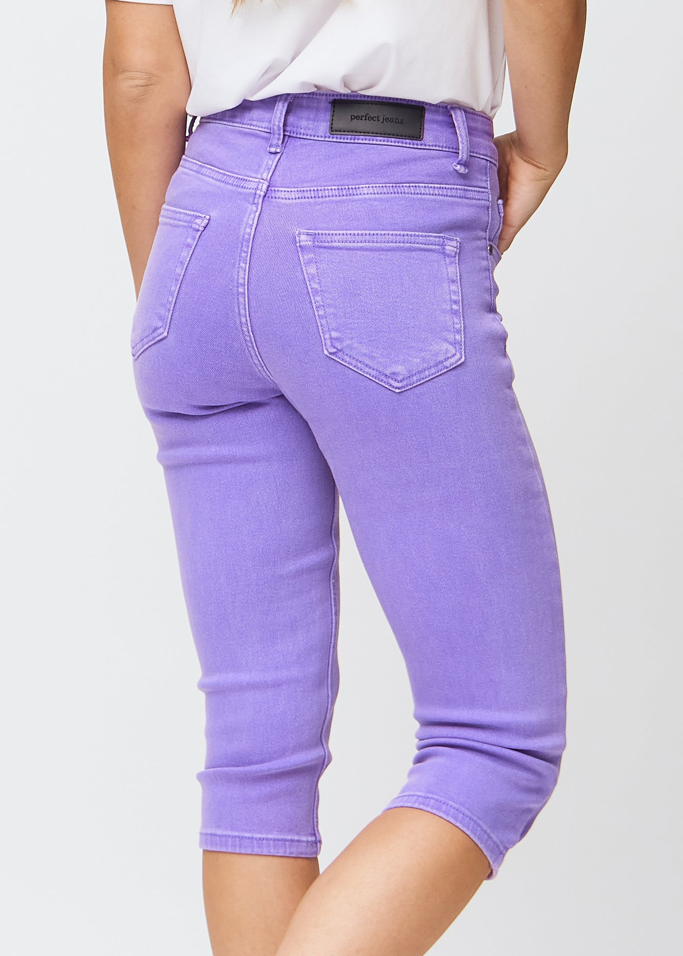 Tæt billede af de lilla slim capris bagfra, så man tydeligt kan se detaljer og lommer.