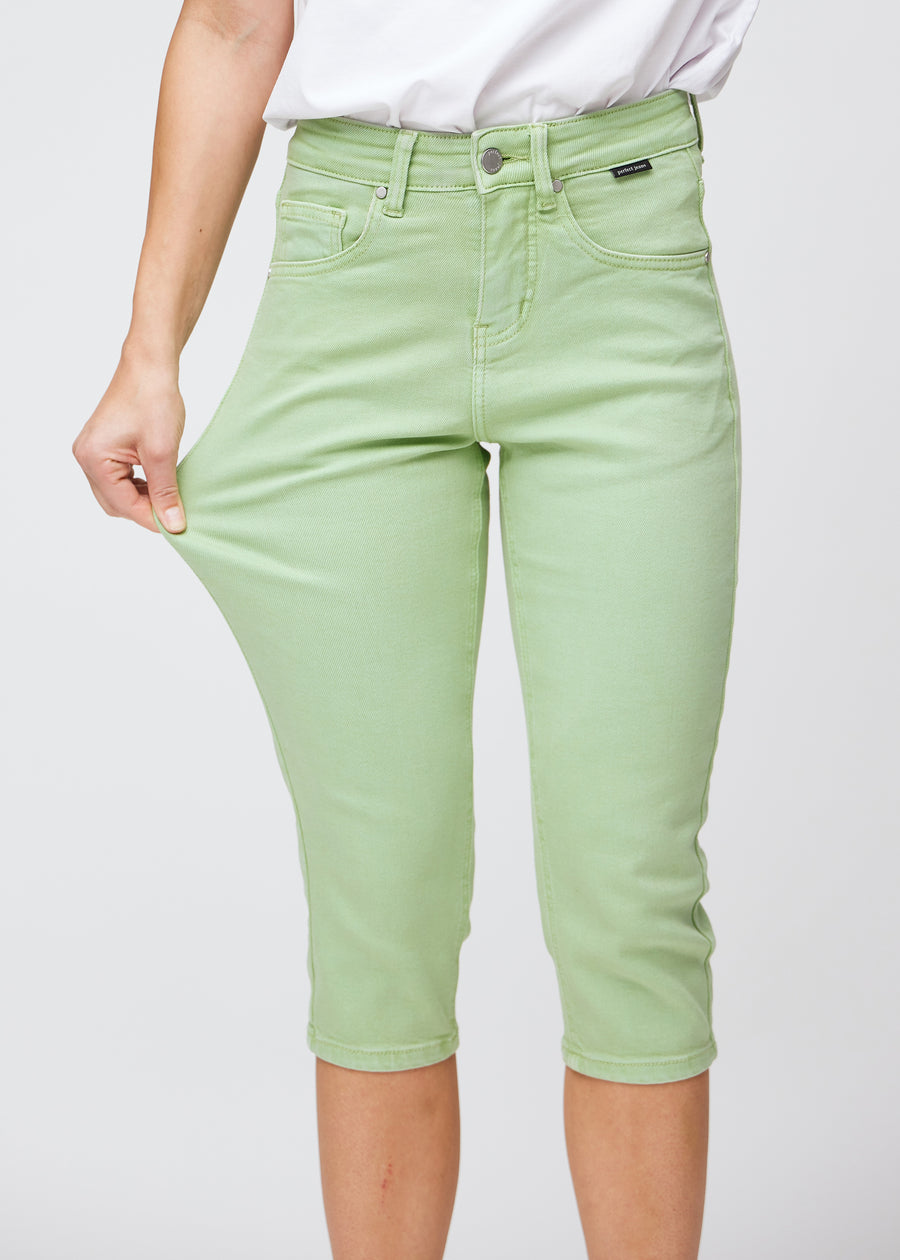 Model strækker caprisene ved låret for at vise det bløde og fleksible stretch.