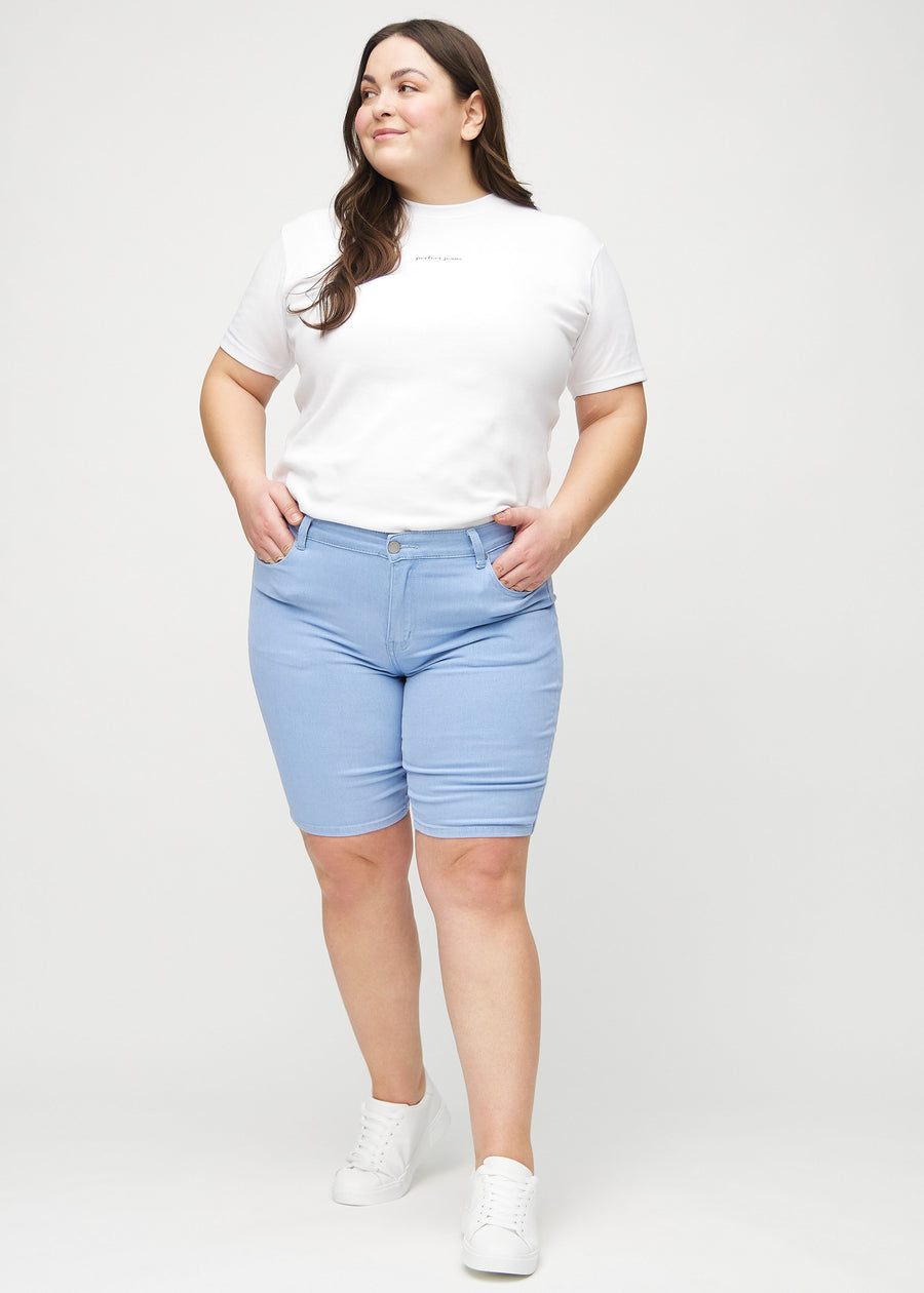 Fuldt billede af en plus-size model i lyseblå skinny middle shorts.