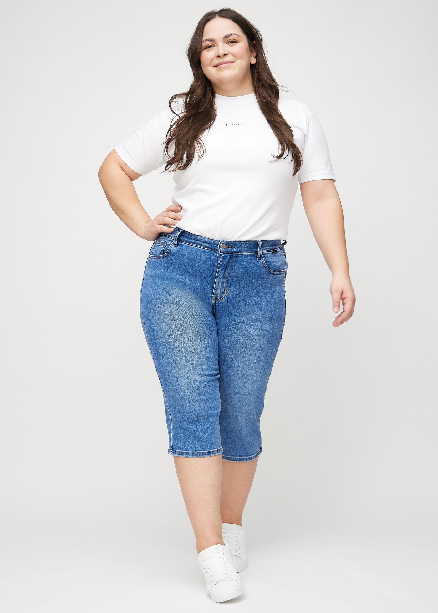 Fuldt billede af en plus-size model i denim regular capris.
