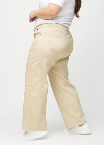 Beige loose jeans set fra siden på en plus-size model.