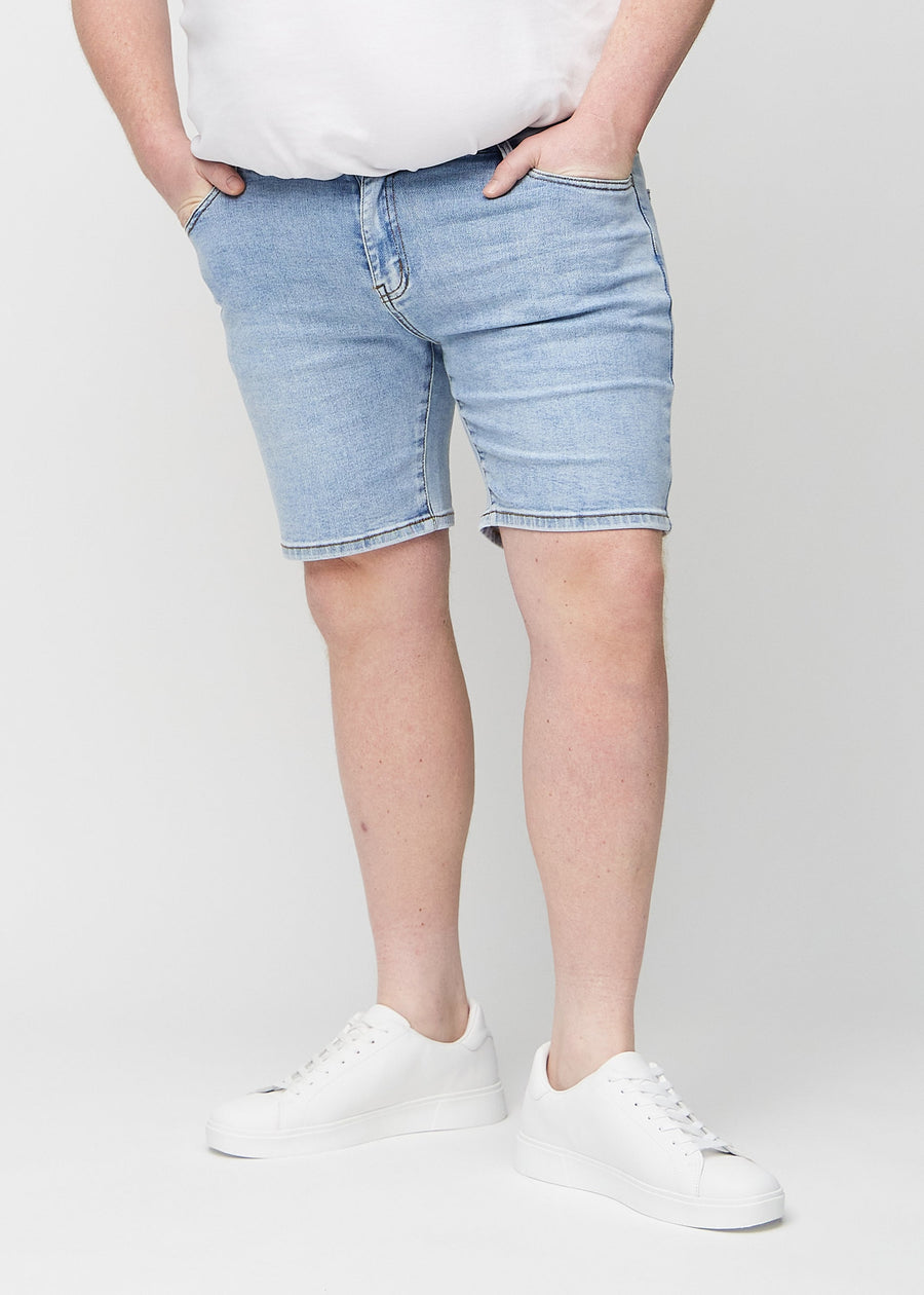 Lys denim regular middle shorts, som sidder lige langs låret og slutter lige over knæet på en plus-size model, set forfra.