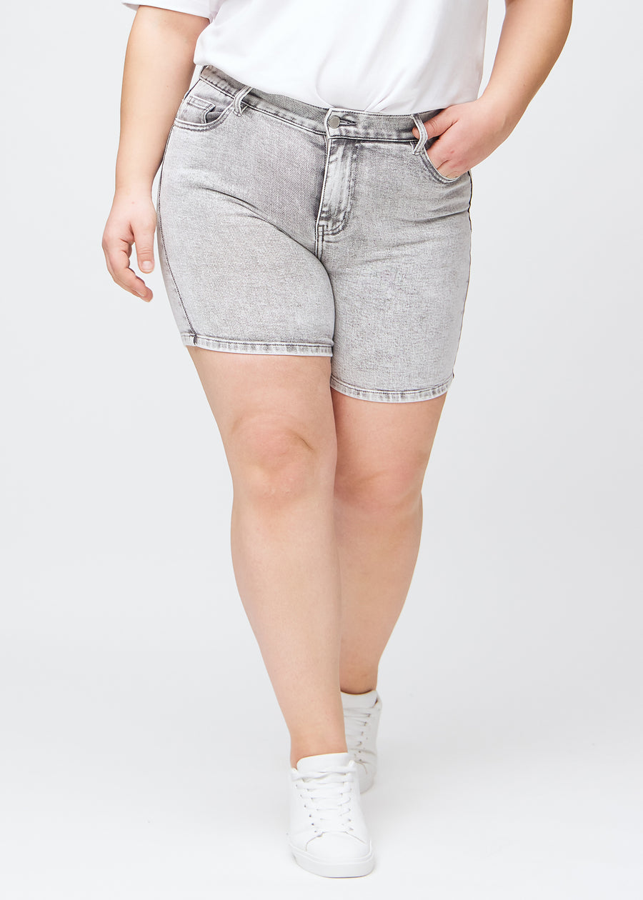 Lysegrå denim skinny short shorts, modelnavn Ashes, som sidder tæt til, og slutter midt på låret på en plus-size model, set forfra.