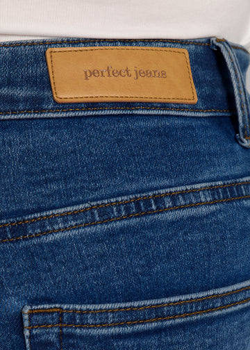 Nærbillede af mørkeblå denim med Perfect Jeans læderpatch bagpå i taljen, på en plus-size model.