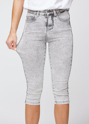 Model strækker caprisene ved låret for at vise stretch.