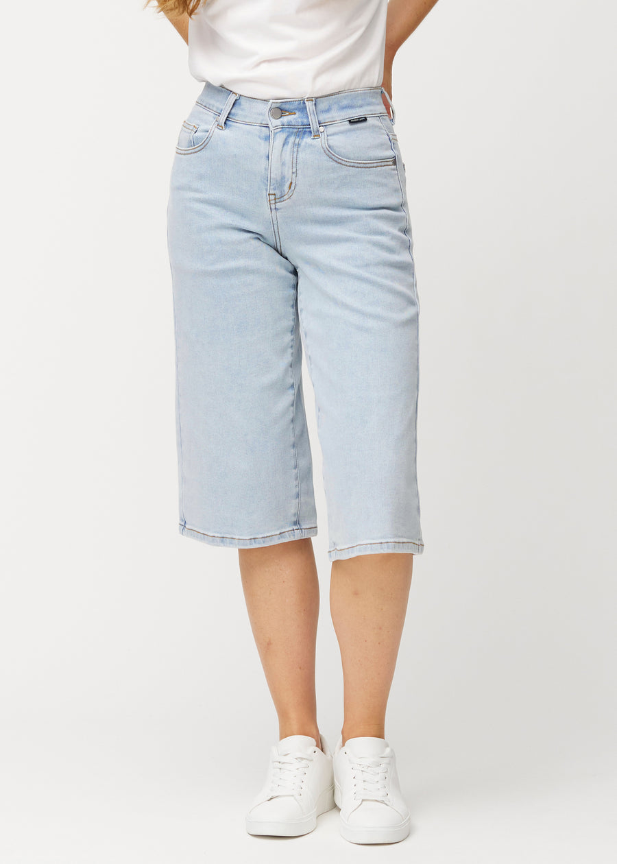 Loose, light blue Waves denim capris that sit close at the hips and fall loosely over the thighs to just below the knee, seen from the front.