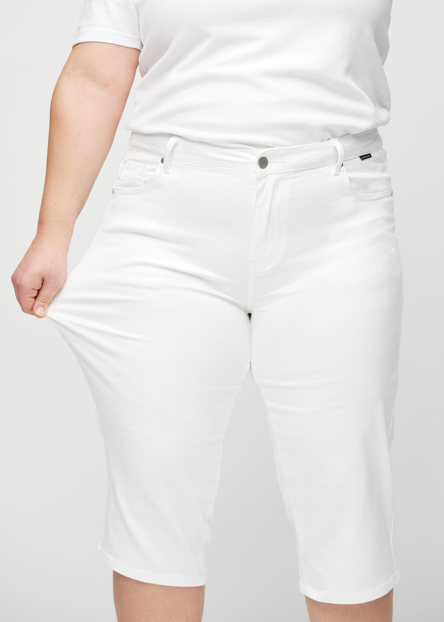 Plus-size model stretches the capris at the thigh to show the stretch.