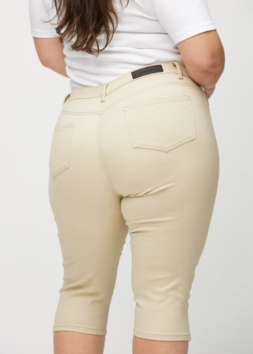 Skinny capris for women in beige fabric, color Gazelles. Close-up from behind on a plus-size model, highlighting pockets and stitching.