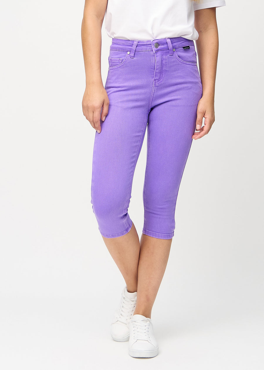Skinny capris for women in pastel purple fabric, color Lavenders. Front view on a model, showing the close-fitting legs ending just below the knee.