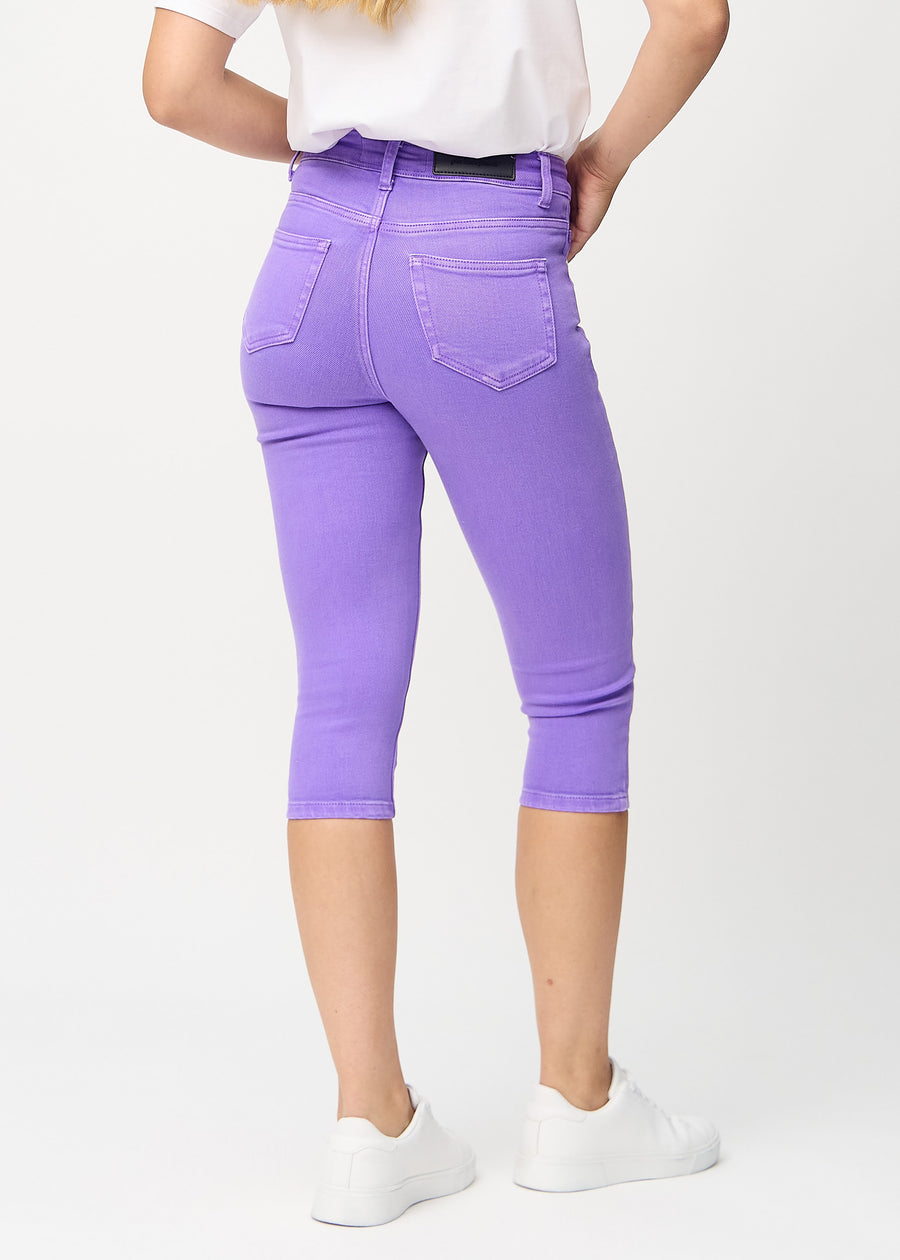Skinny capris for women in pastel purple fabric, color Lavenders. Back view on a model, showing the fit and back pockets.