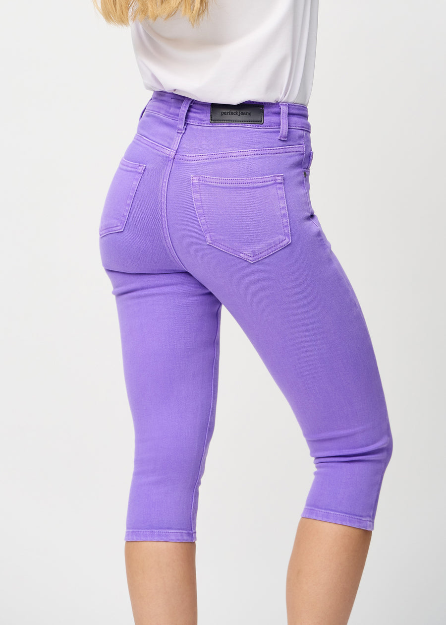 Skinny capris for women in pastel purple fabric, color Lavenders. Close-up from behind on a model, highlighting pockets and stitching.