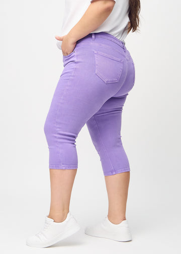 Skinny capris for women in pastel purple fabric, color Lavenders. Side view on a plus-size model, showing the fitted cut.