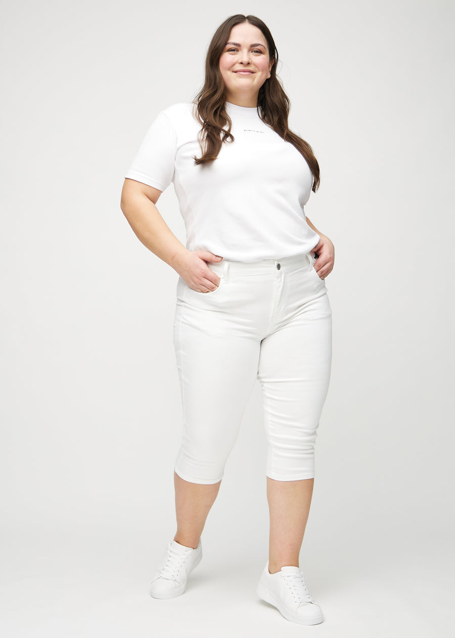 Full image of a plus-size model in white skinny capris.
