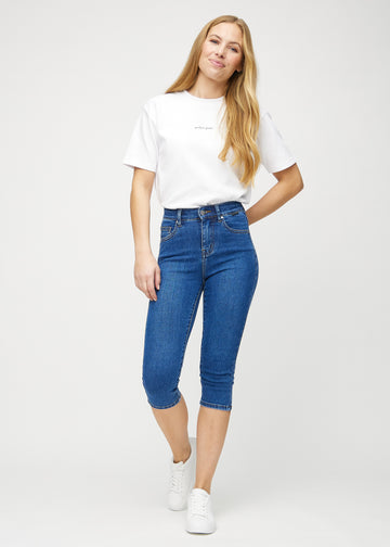 Skinny capris for women in dark blue denim, color Oceans. Full-length view of a model wearing the capris.