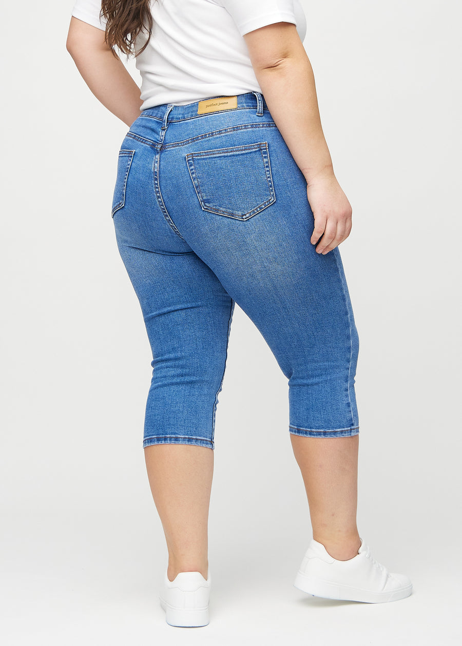 Denim skinny capris seen from the back on a plus-size model, so the entire product can be seen.