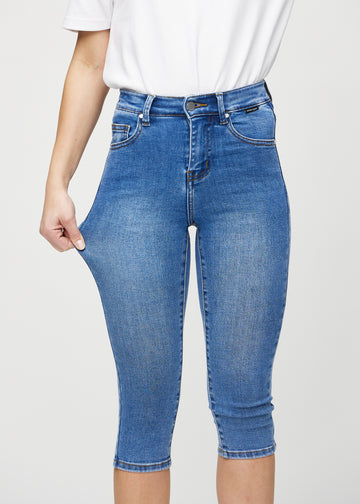 The model stretches the capris at the thigh to show the stretch.