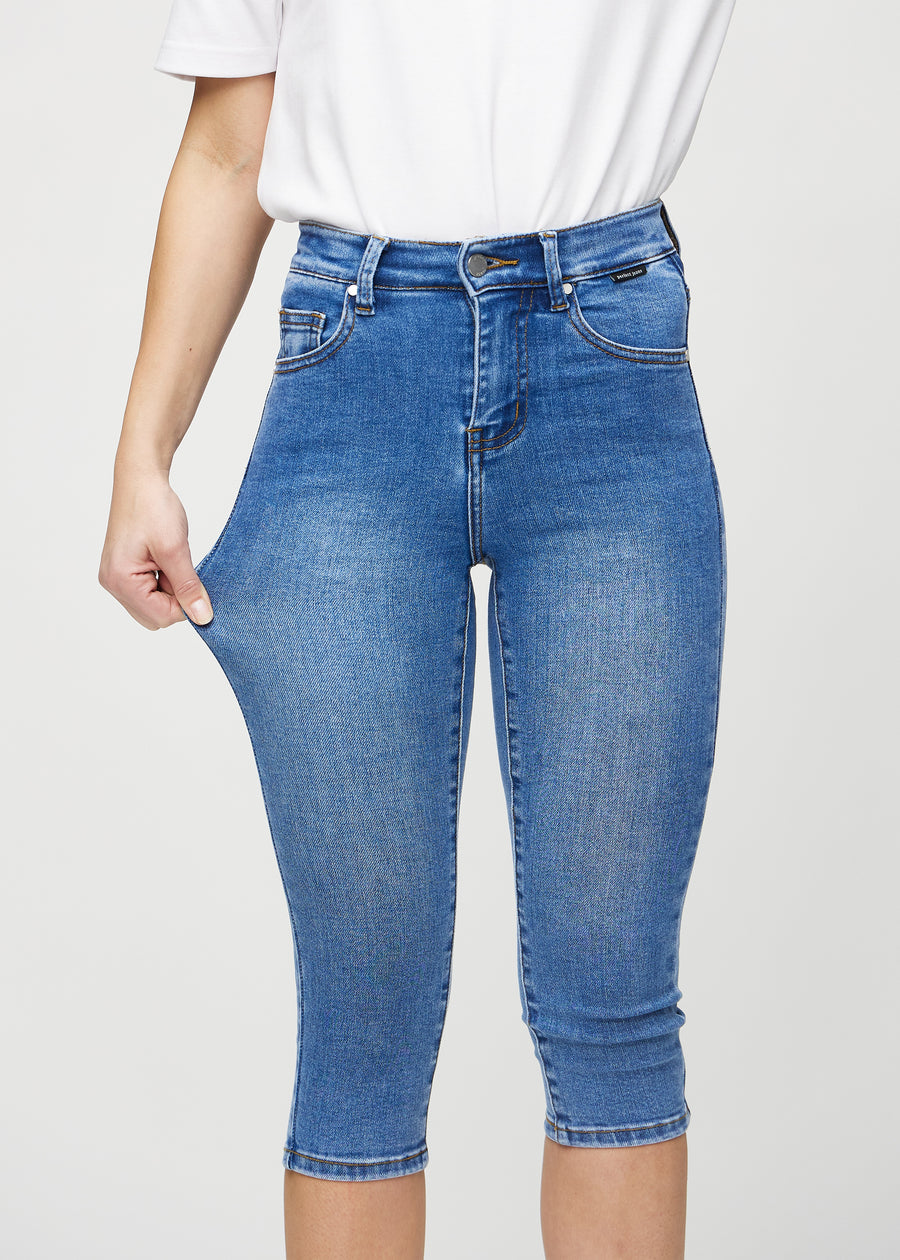 The model stretches the capris at the thigh to show the stretch.