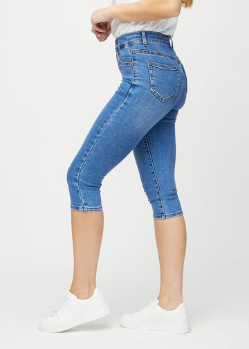 Denim skinny capris seen from the side on a model.