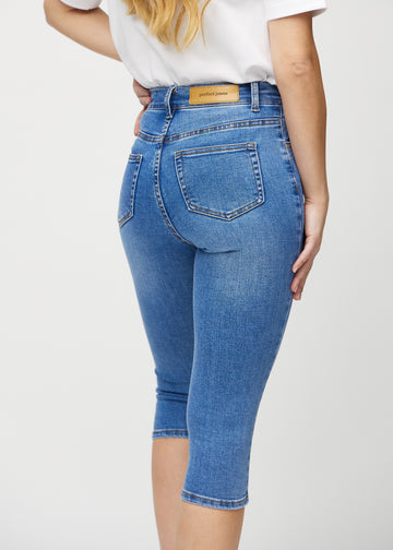 Denim skinny capris seen from the back close up to show details.