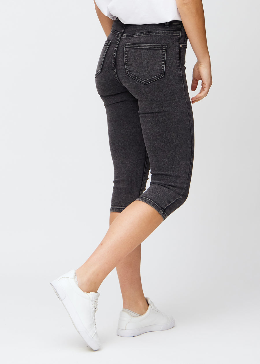 Skinny capris for women in dark grey denim, color Shadows. Back view on a model, showing the fit and back pockets.