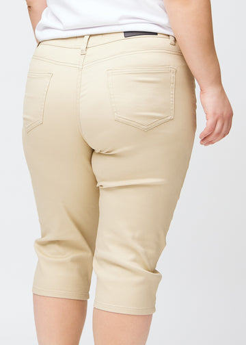  Close-up image of the back on a plus-size model wearing beige slim capris, detailed focus on pockets and stitching.