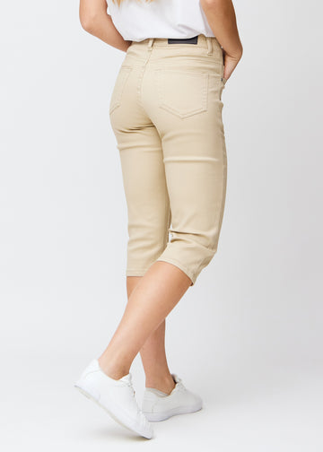 Beige slim capris seen from the back, the full product is shown on the model with focus on fit and length.
