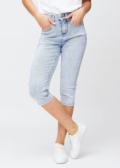 Light blue denim slim capris, colour Waves, with a tight fit that shapes the legs and ends just below the knee, seen from the front.