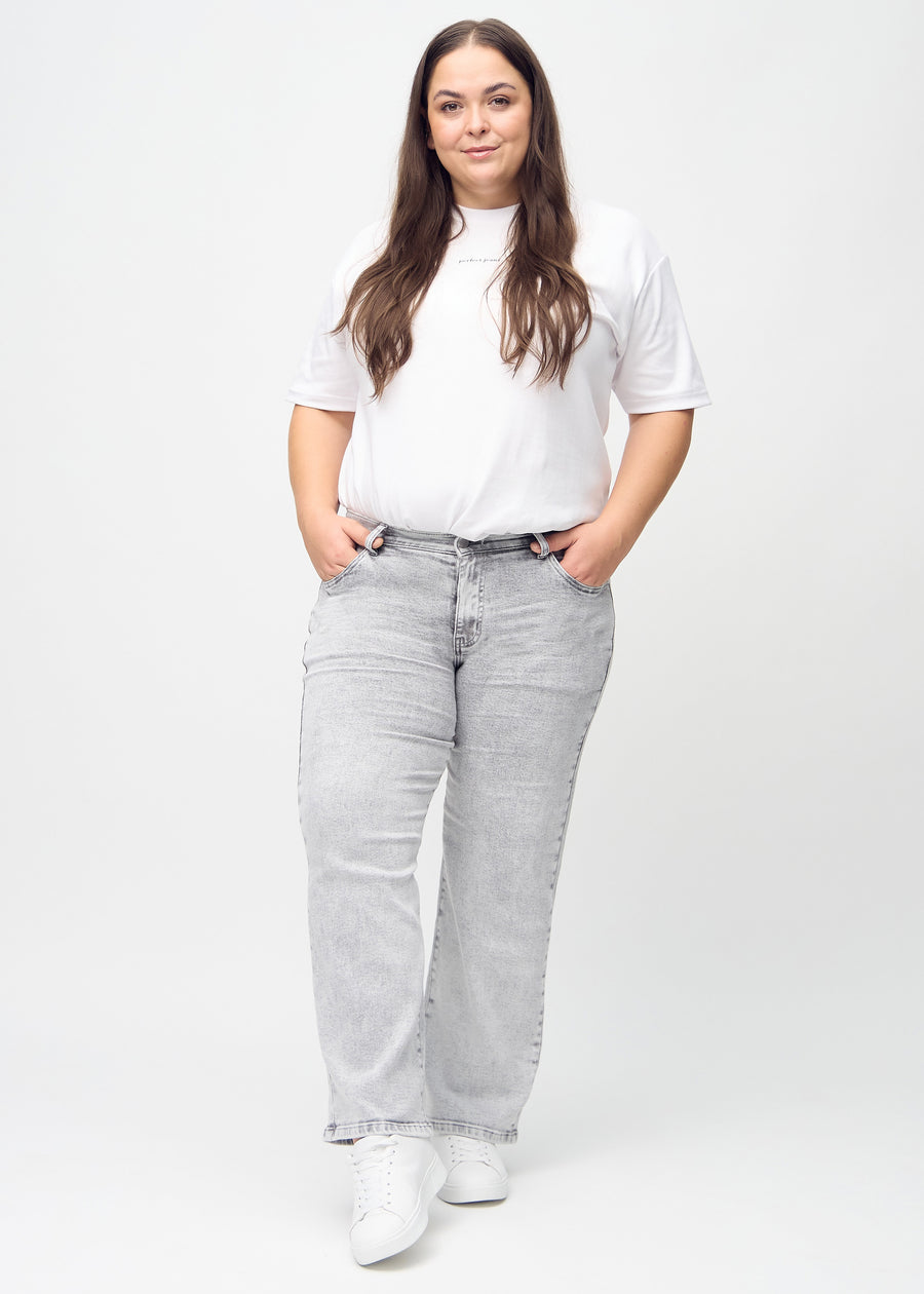 Full image of a plus-size model in light grey denim loose jeans.