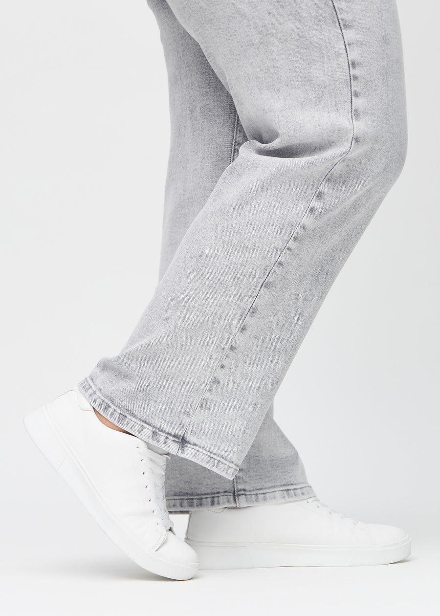 The ankles of a plus-size model, so you can see how loosely the jeans fit.