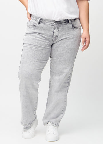 Light grey denim loose jeans, model name Ashes, which has a loose fit with plenty of width in the legs on a plus-size model, seen from the front.