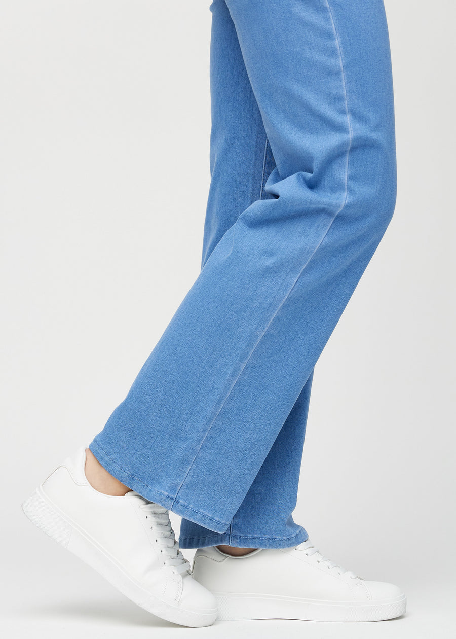 Loose jeans for women in blue, color Geraniums. Close-up at the ankles on a model, showing the wide leg openings.