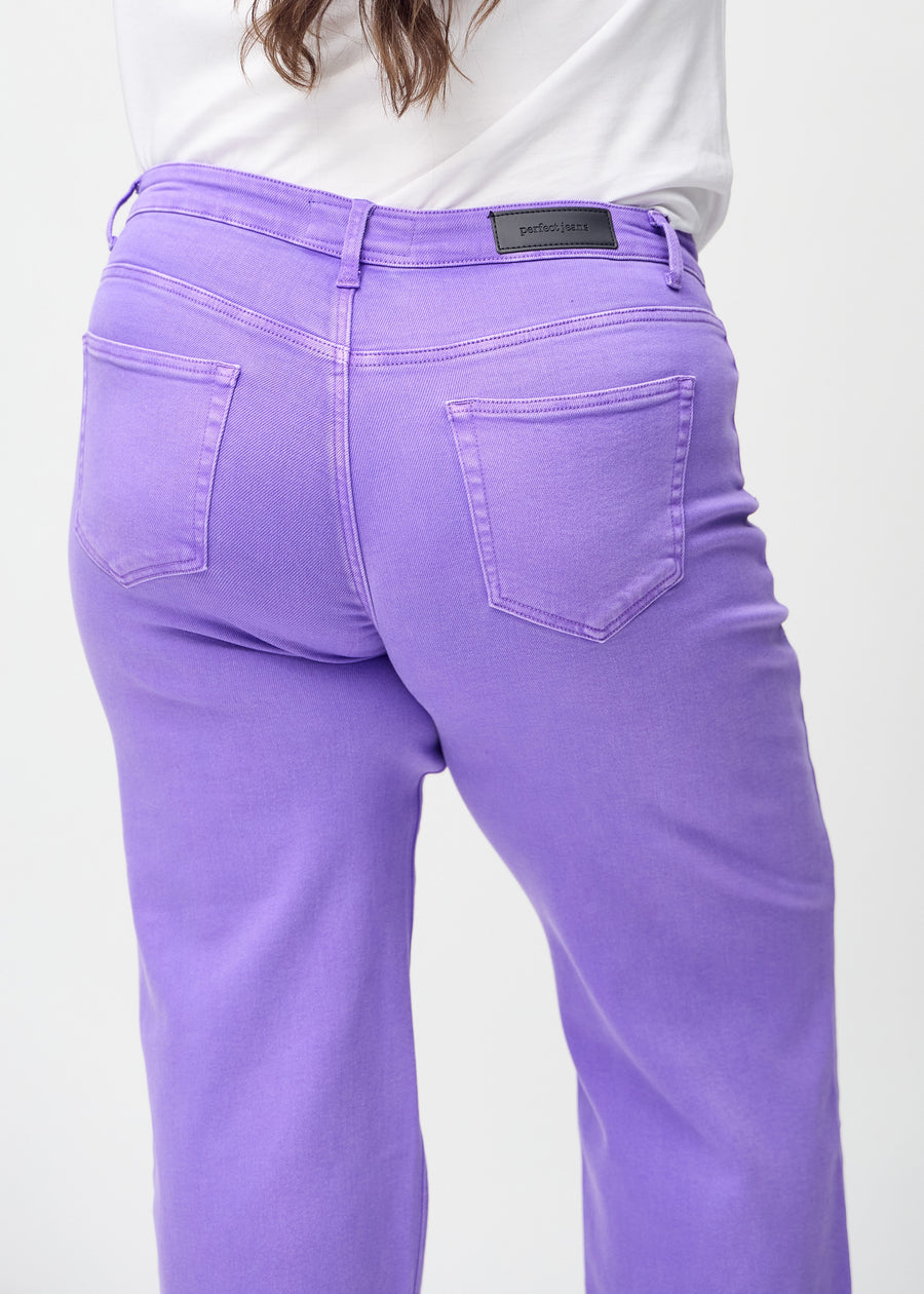 Purple loose jeans seen from the back up close on a plus-size model to show details.
