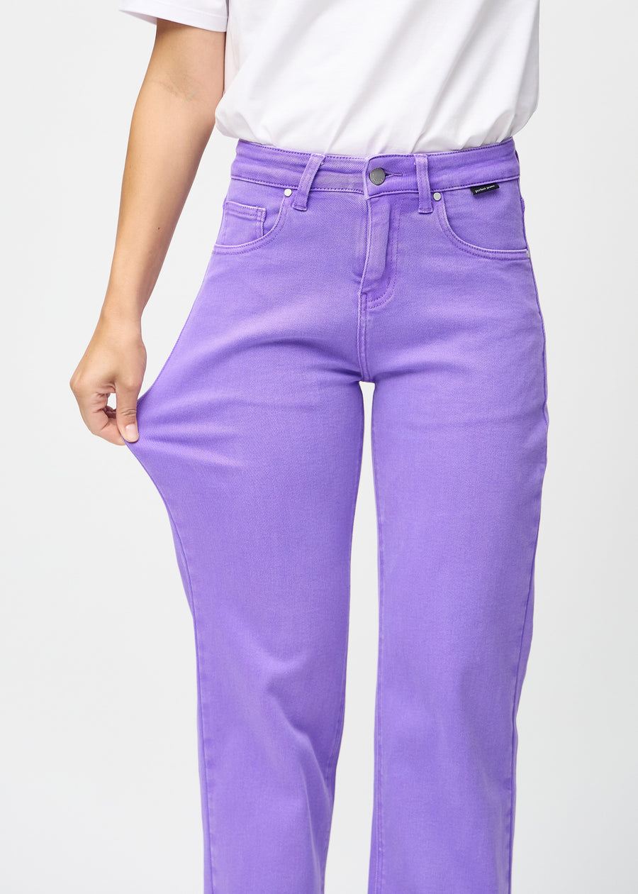 The model stretches the jeans at the thigh to show the stretch.
