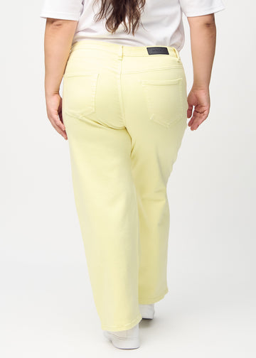 Loose jeans for women in light yellow, color Lemonades. Back view on a plus-size model, showing the overall relaxed fit.