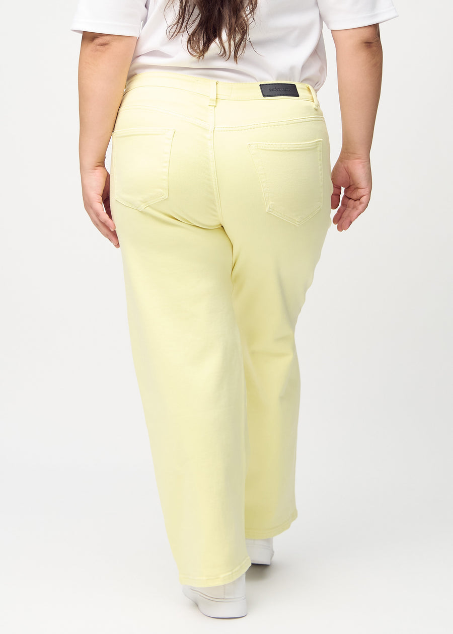 Loose jeans for women in light yellow, color Lemonades. Back view on a plus-size model, showing the overall relaxed fit.