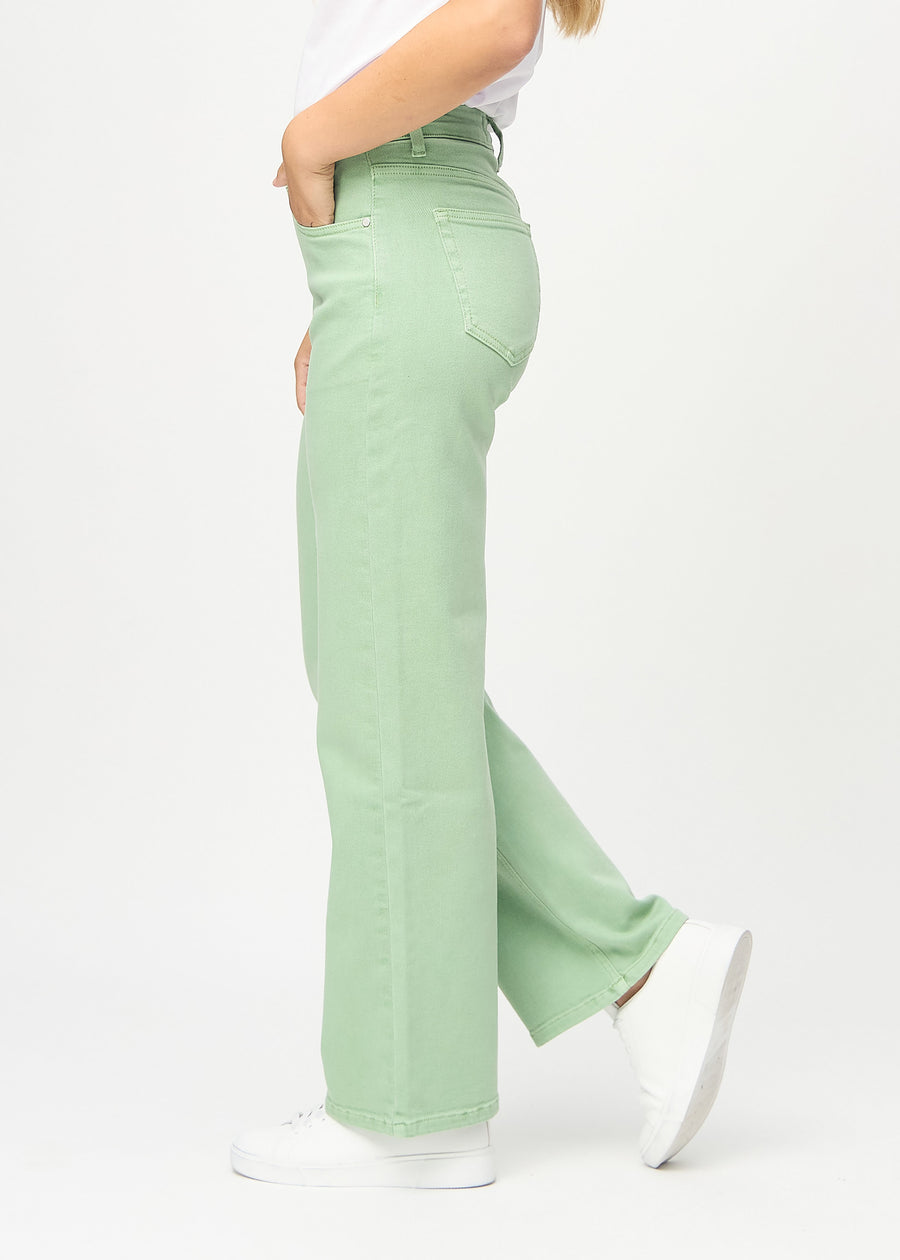 Loose jeans for women in light green, color Mints. Side view on a model, showing the loose fit.