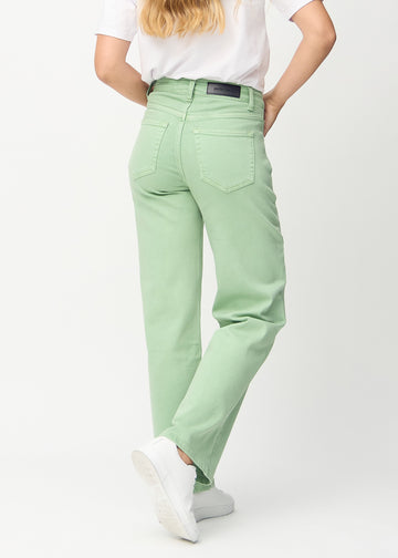 Loose jeans for women in light green, color Mints. Back view on a model, showing the overall relaxed fit.