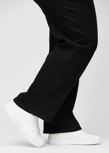 Loose jeans for women in black, color Ravens. Close-up at the ankles on a plus-size model, showing the wide leg openings.