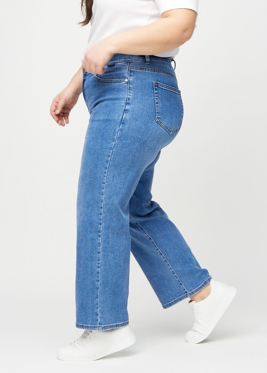 Denim loose jeans seen from the side on a plus-size model.