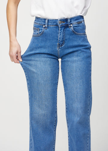 The model stretches the jeans at the thigh to show the stretch.