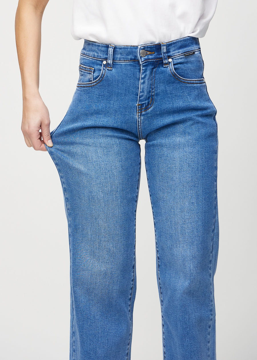 The model stretches the jeans at the thigh to show the stretch.
