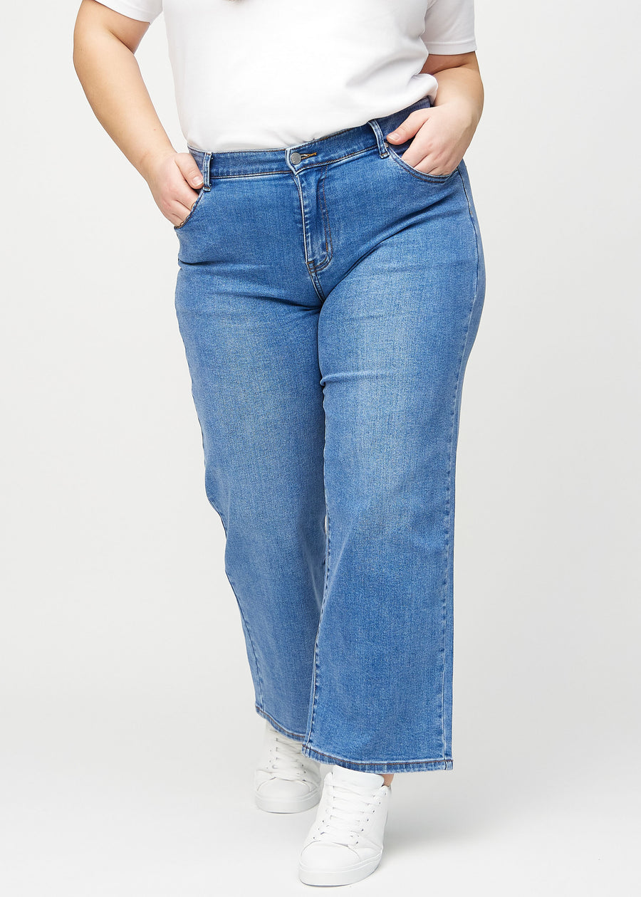 Denim loose jeans, model name Rivers, which is loose-fitting with plenty of width in the legs on a plus-size model, seen from the front.