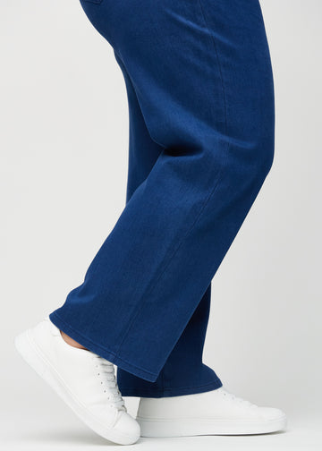 Loose jeans for women in dark blue, color Royals. Close-up at the ankles on a plus-size model, showing the wide leg openings.