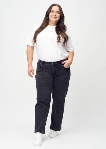Full image of a plus-size model in dark grey denim loose jeans.