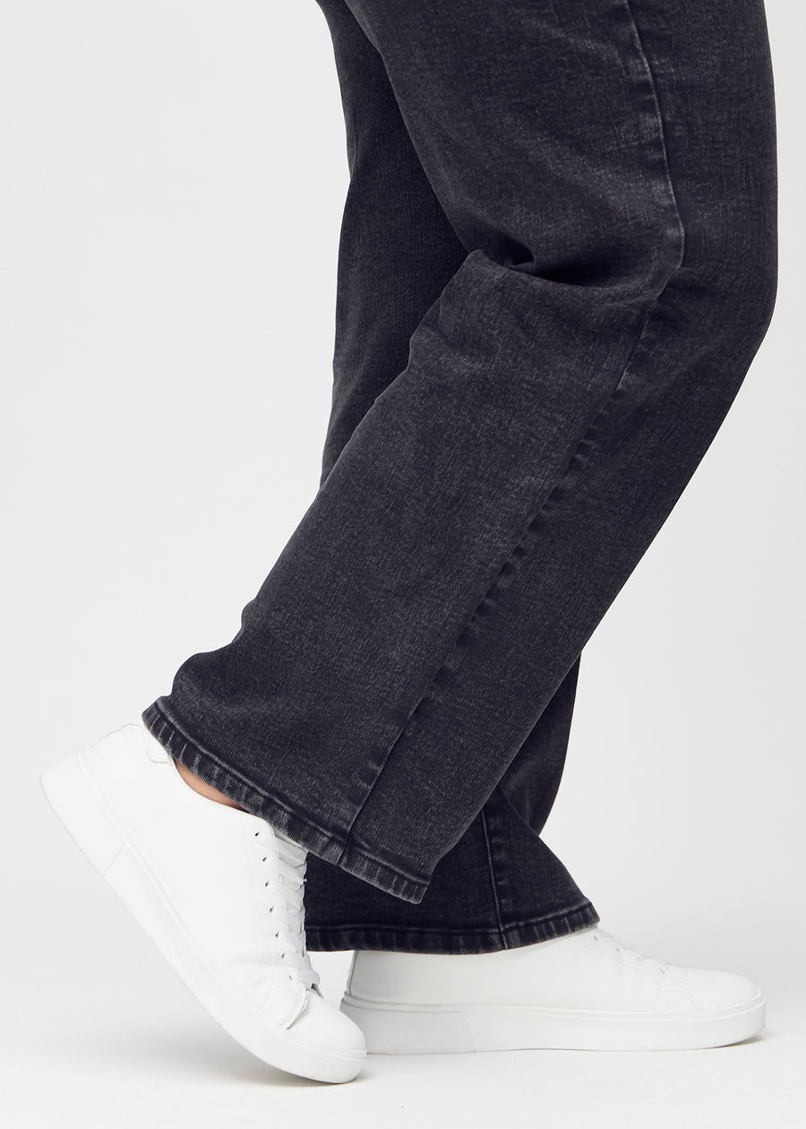 The ankles of a plus-size model, so you can see how loosely the jeans fit.