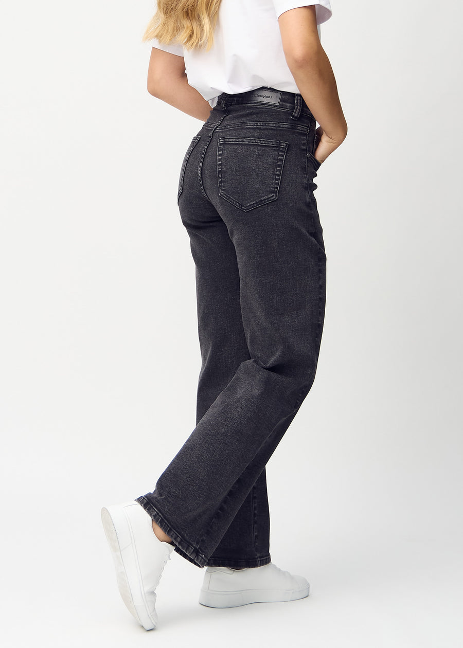 Dark grey denim loose jeans seen from the back, so the entire product can be seen.