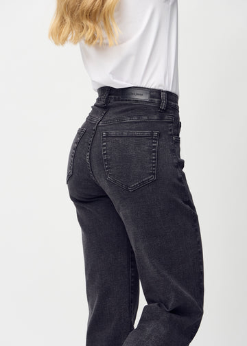 Dark grey denim loose jeans seen from the back close up to show details.