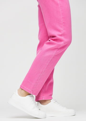 Regular jeans for women in light pink, color Flamingos. Close-up at the ankles on a model, showing the straight leg openings.