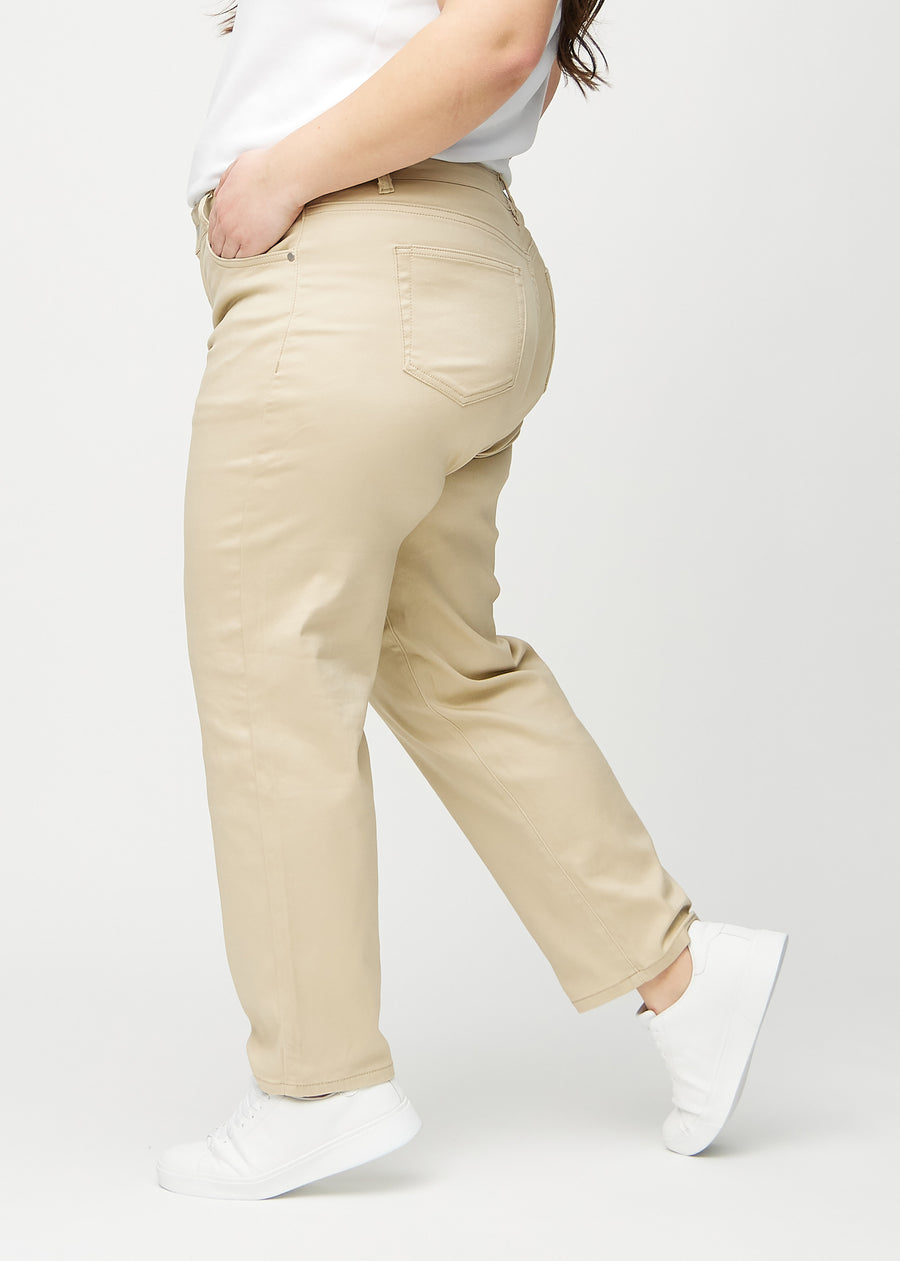 Beige regular jeans seen from the side on a plus-size model.