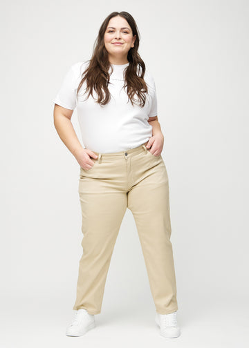 Full image of a plus-size model in beige regular jeans.